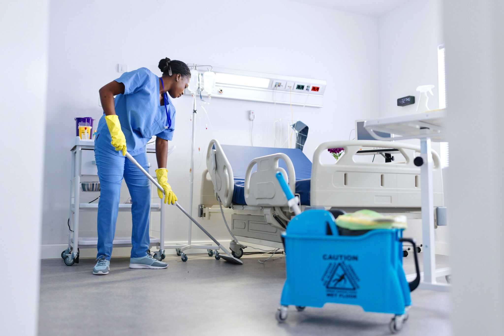 Healthcare worker cleaning patient room